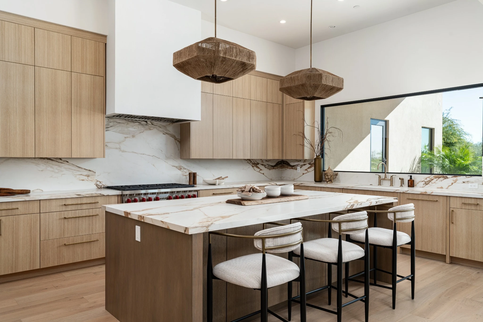 Oak kitchen with veined stone island and woven pendant lights